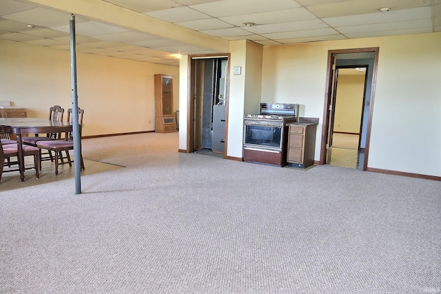 interior space with baseboards, a paneled ceiling, and light colored carpet
