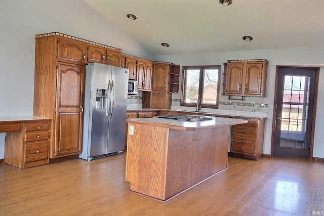 kitchen featuring brown cabinets, a healthy amount of sunlight, open shelves, and stainless steel appliances