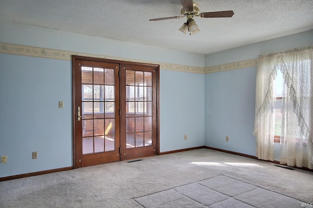 empty room with visible vents, a wealth of natural light, and carpet flooring
