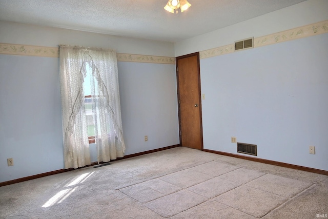 spare room featuring carpet and visible vents