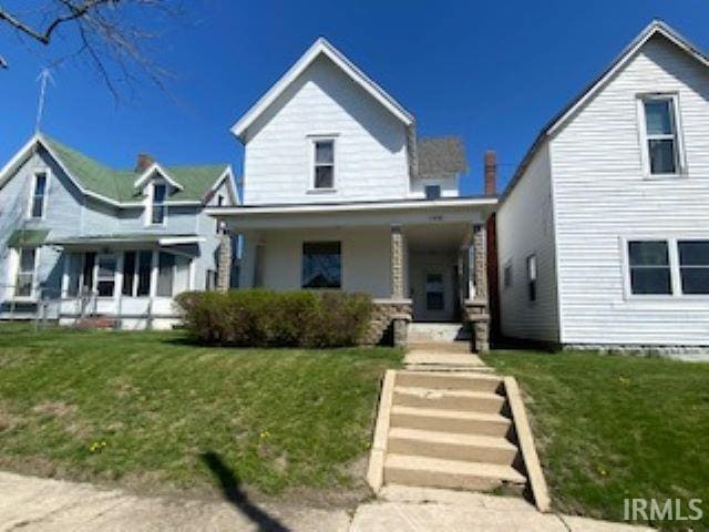 view of front of home with a porch and a front yard