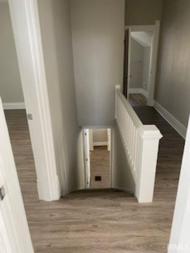 stairs featuring wood finished floors and baseboards