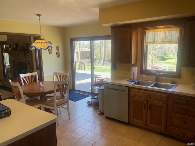 15516 Menominee Dr, Plymouth, IN 46563 - kitchen featuring light tile patterned floors, decorative light fixtures, a sink, light countertops, and stainless steel dishwasher