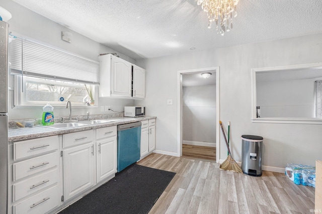 3930 Abbott St, Fort Wayne, IN 46806 - kitchen featuring a sink, a textured ceiling, dishwashing machine, white microwave, and light wood-style flooring