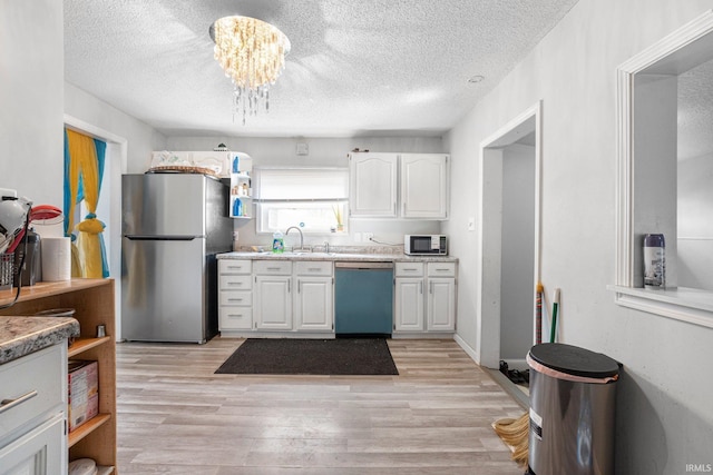 3930 Abbott St, Fort Wayne, IN 46806 - kitchen with white cabinets, dishwasher, light countertops, freestanding refrigerator, and a textured ceiling