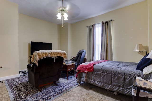 bedroom with ceiling fan, baseboards, and carpet