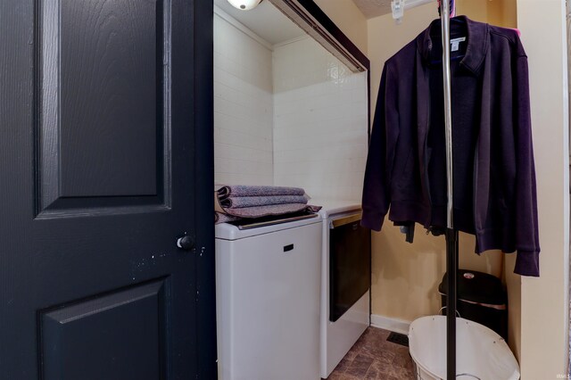 laundry room with washer and dryer, laundry area, and stone finish flooring