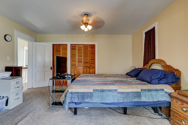 carpeted bedroom with a ceiling fan and multiple closets
