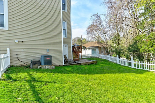 view of yard with central AC, a fenced backyard, and a deck