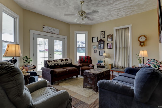 living room featuring a textured ceiling, french doors, and a ceiling fan