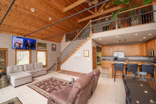 living room featuring light tile patterned floors, high vaulted ceiling, stairway, and wooden ceiling