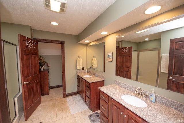 bathroom featuring a sink, visible vents, two vanities, and a shower stall