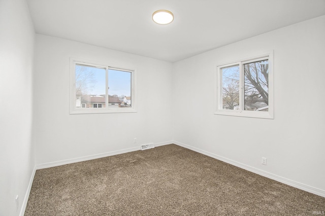 214 Parkwood Ln, South Bend, IN 46619 - spare room with a wealth of natural light, dark colored carpet, visible vents, and baseboards