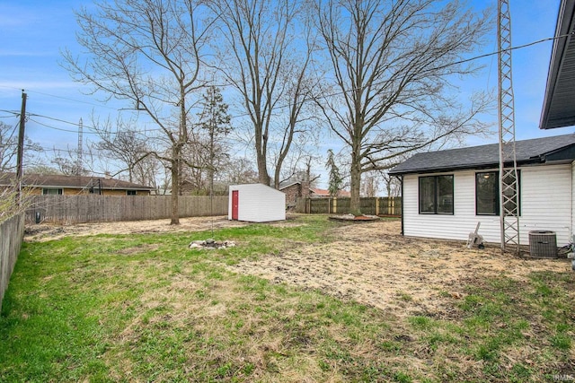 214 Parkwood Ln, South Bend, IN 46619 - view of yard with a shed, central air condition unit, a fenced backyard, and an outbuilding