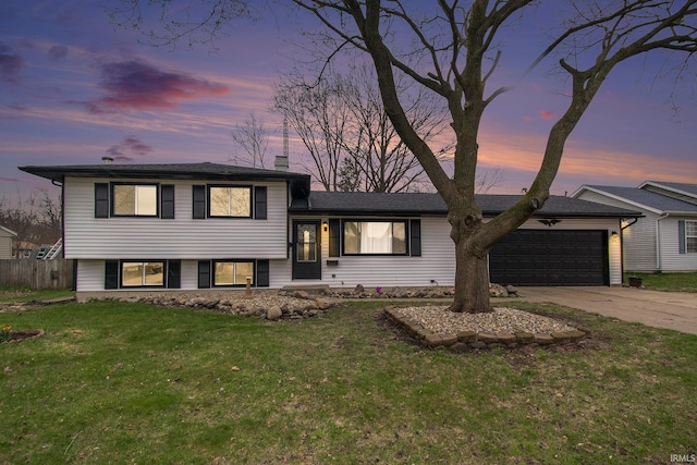 214 Parkwood Ln, South Bend, IN 46619 - split level home with a garage, a chimney, fence, concrete driveway, and a front lawn
