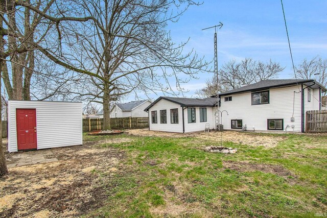 214 Parkwood Ln, South Bend, IN 46619 - rear view of property with a yard, a fenced backyard, an outdoor structure, and a storage unit