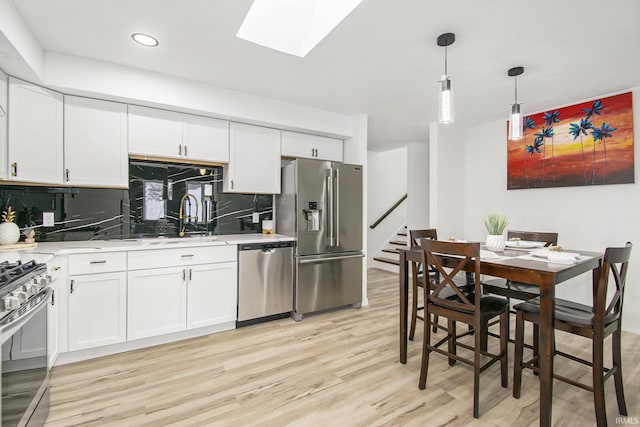 214 Parkwood Ln, South Bend, IN 46619 - kitchen featuring backsplash, light wood-type flooring, appliances with stainless steel finishes, and a skylight