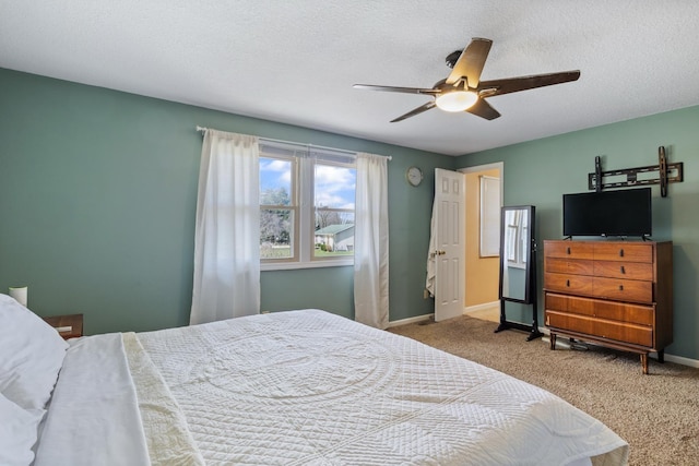 carpeted bedroom with ceiling fan, baseboards, and a textured ceiling