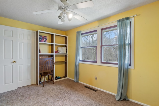 bedroom featuring a textured ceiling, carpet, visible vents, and baseboards