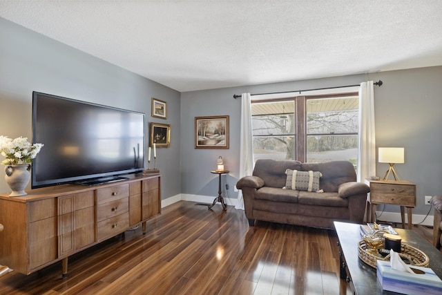 living room featuring dark wood finished floors, baseboards, and a textured ceiling