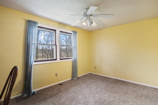 empty room featuring baseboards, a ceiling fan, a textured ceiling, and carpet
