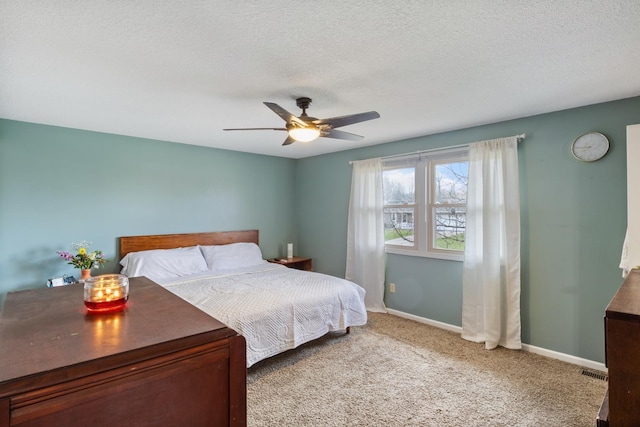 carpeted bedroom featuring ceiling fan, baseboards, a textured ceiling, and visible vents