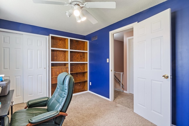 carpeted home office featuring a ceiling fan and baseboards