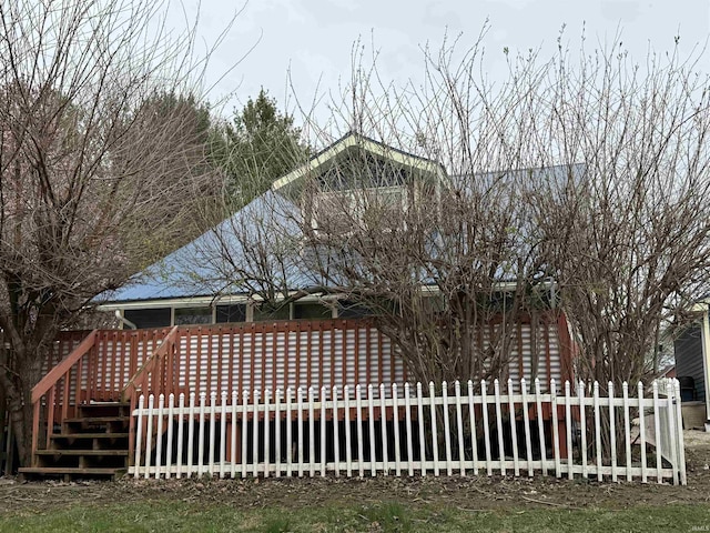 rear view of property with fence and a deck