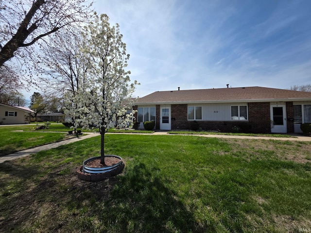 ranch-style house featuring brick siding and a front yard
