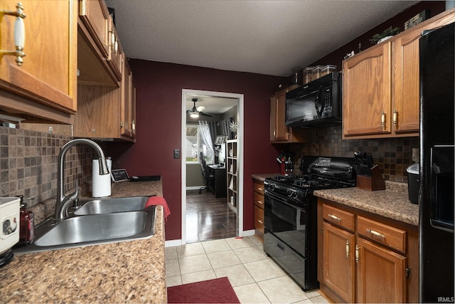 kitchen with a sink, backsplash, a ceiling fan, black appliances, and light tile patterned floors