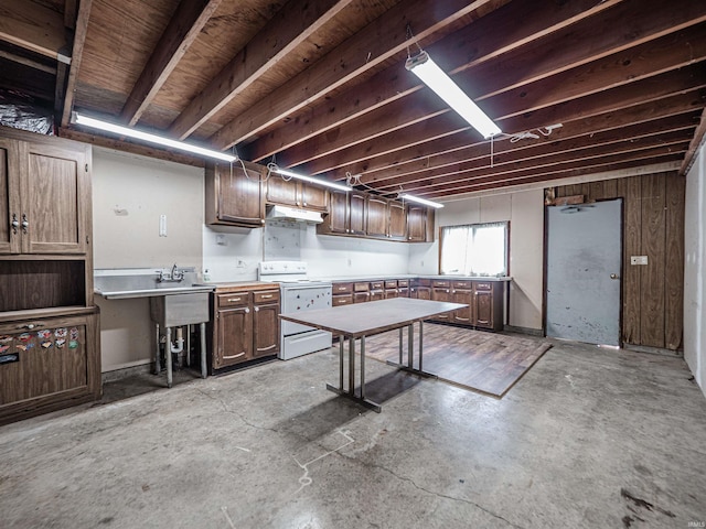 8901 Vienna Rd, Evansville, IN 47720 - kitchen featuring light countertops, under cabinet range hood, white range with electric cooktop, and unfinished concrete flooring