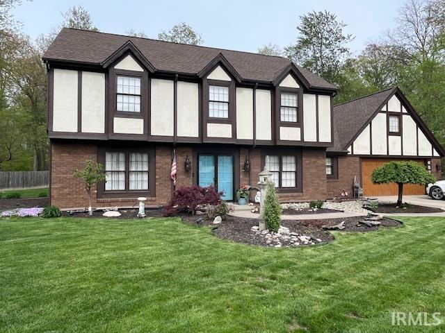 6827 Belle Plain Cv, Fort Wayne, IN 46835 - back of house with a yard, brick siding, fence, and a shingled roof