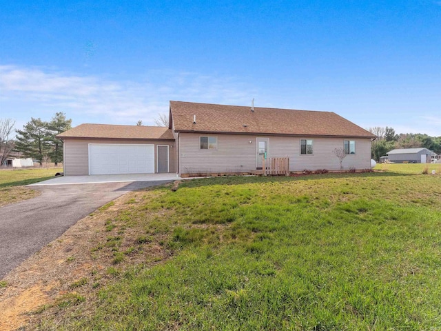 view of front of house featuring a garage, driveway, and a front lawn