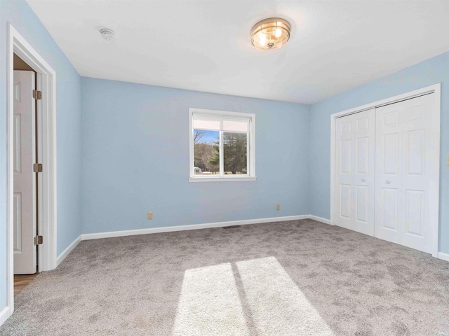 unfurnished bedroom featuring carpet floors, a closet, and baseboards