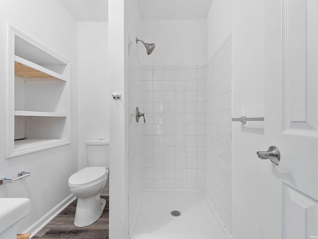 bathroom featuring a stall shower, wood finished floors, and toilet