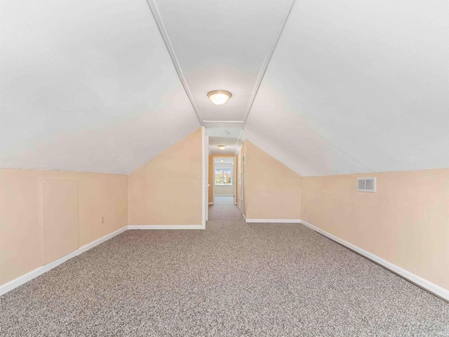 bonus room with lofted ceiling, baseboards, carpet flooring, and visible vents