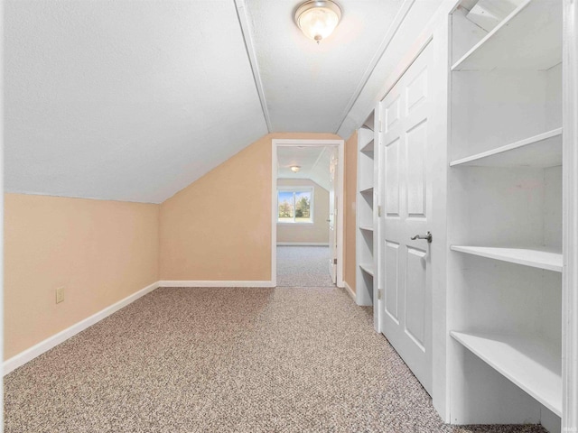 bonus room featuring baseboards, vaulted ceiling, and carpet flooring