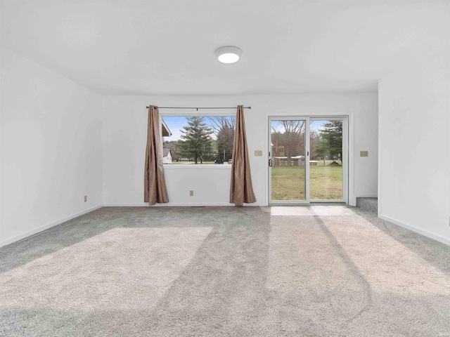 carpeted empty room with plenty of natural light and baseboards