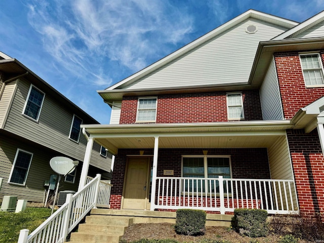 view of front facade featuring a porch and brick siding