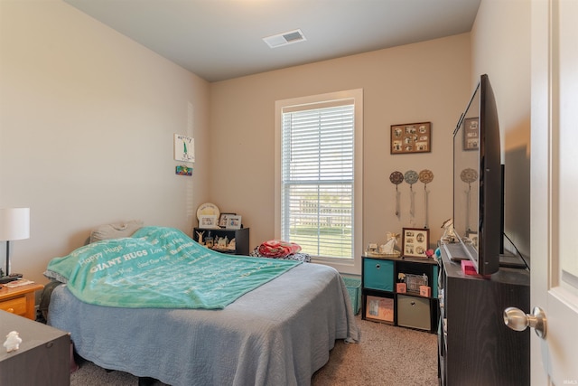 carpeted bedroom featuring visible vents and multiple windows