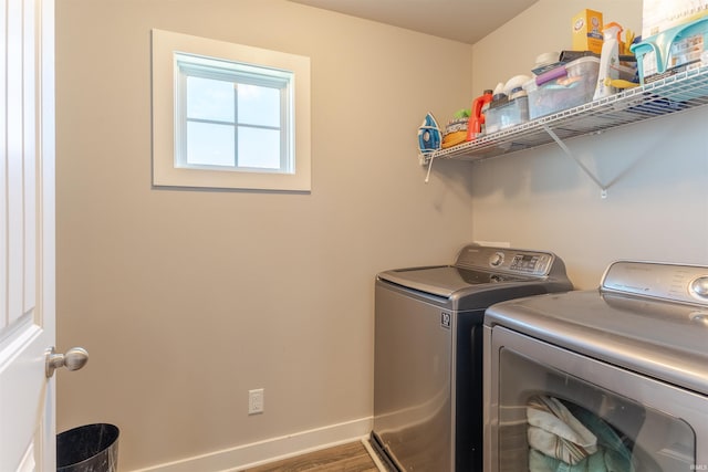laundry area featuring washing machine and clothes dryer, wood finished floors, baseboards, and laundry area