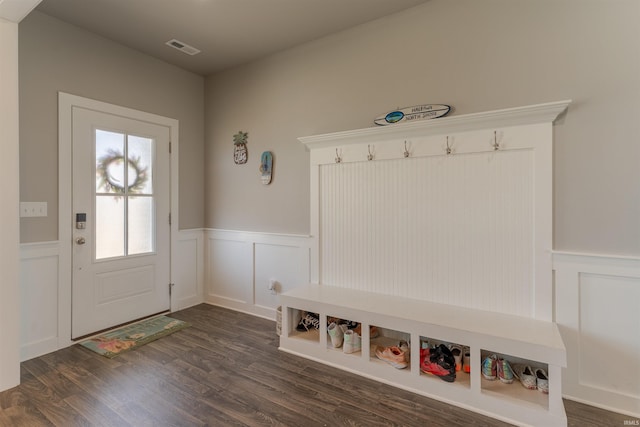 mudroom featuring a wainscoted wall, visible vents, dark wood-type flooring, and a decorative wall
