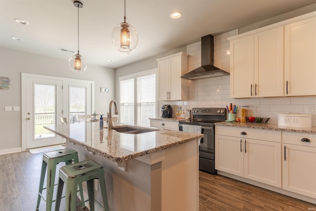 kitchen with backsplash, wall chimney range hood, a sink, and electric range