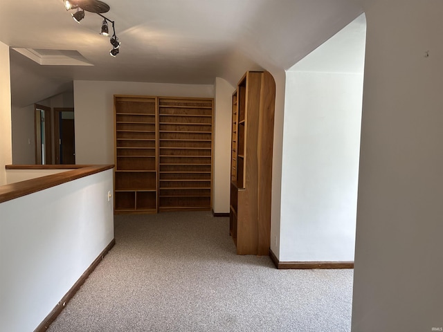 6065 Gladden Dr, Indianapolis, IN 46220 - hallway featuring vaulted ceiling, baseboards, carpet floors, and rail lighting