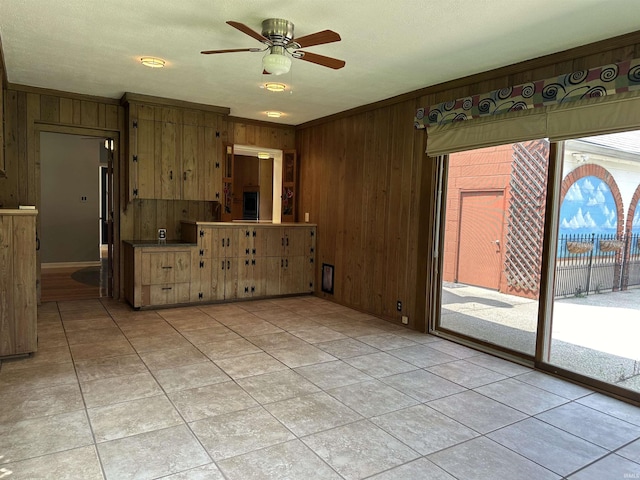 6065 Gladden Dr, Indianapolis, IN 46220 - empty room with ornamental molding, wood walls, a ceiling fan, and light tile patterned floors