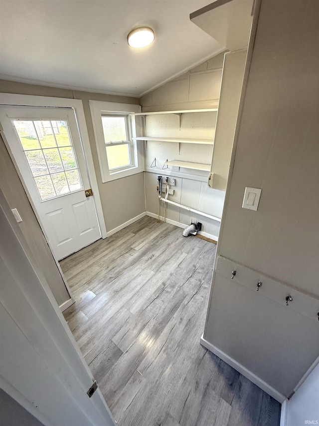 laundry area with light wood-style floors and baseboards