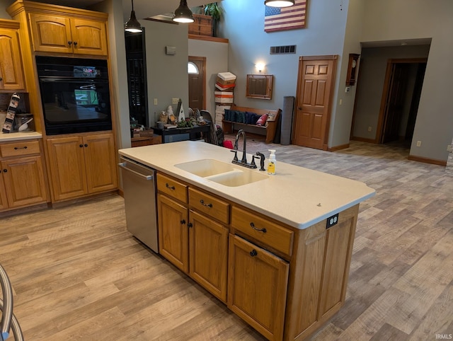 kitchen with visible vents, stainless steel dishwasher, a sink, black oven, and open floor plan