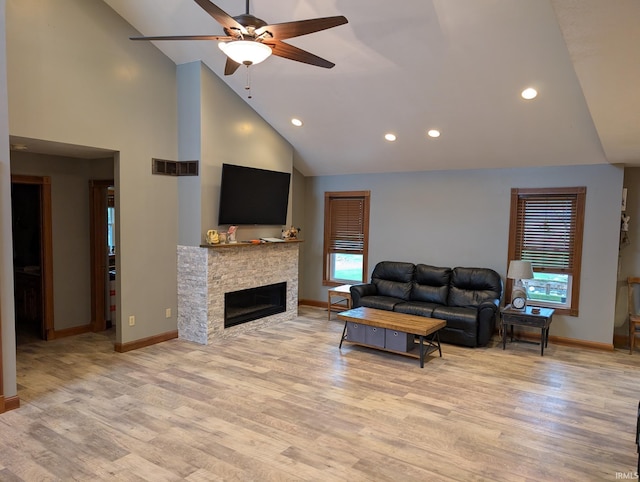 living area featuring baseboards, visible vents, high vaulted ceiling, ceiling fan, and a fireplace