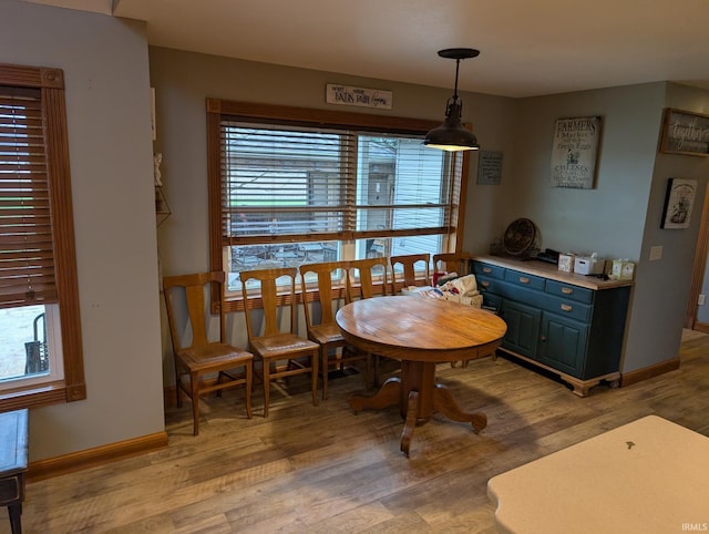dining space featuring light wood-type flooring, baseboards, and a healthy amount of sunlight