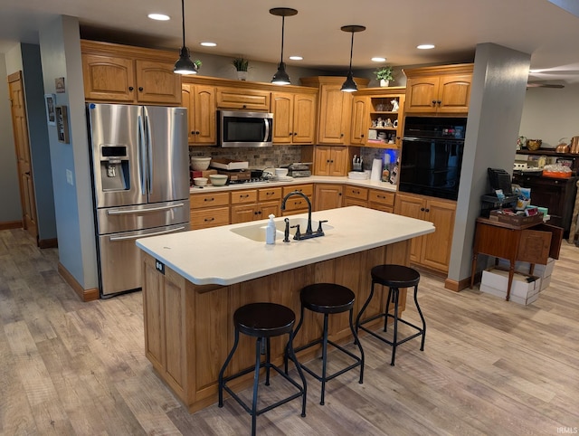 kitchen featuring open shelves, light wood-type flooring, stainless steel appliances, and a sink
